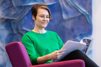 Katri Hämeen-Anttila lukee tutkimusta yliopiston aulassa.