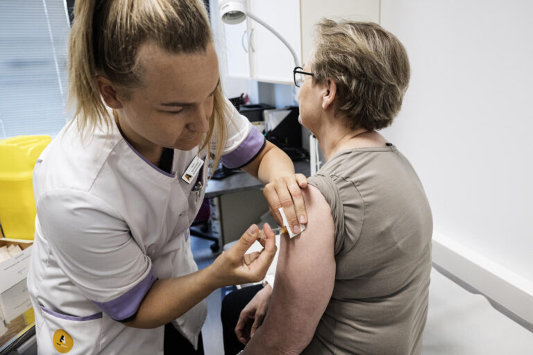 Sairaanhoitaja rokottamassa apteekin Terveyspisteessä.