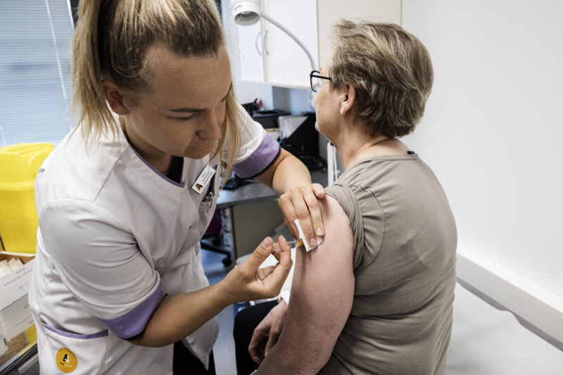 Sairaanhoitaja rokottamassa apteekin Terveyspisteessä.