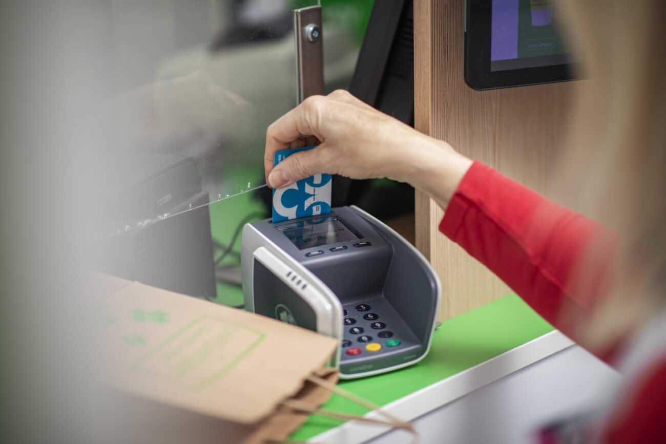 Asiakas maksamassa lääkeostojaan apteekin kassalla.