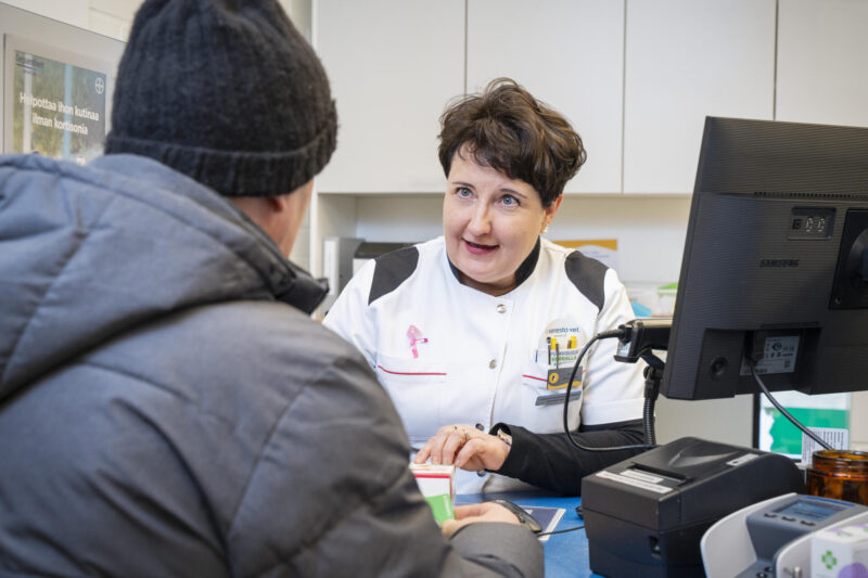 Kirsi Putkonen palvelemassa asiakasta apteekin reseptitiskissä.