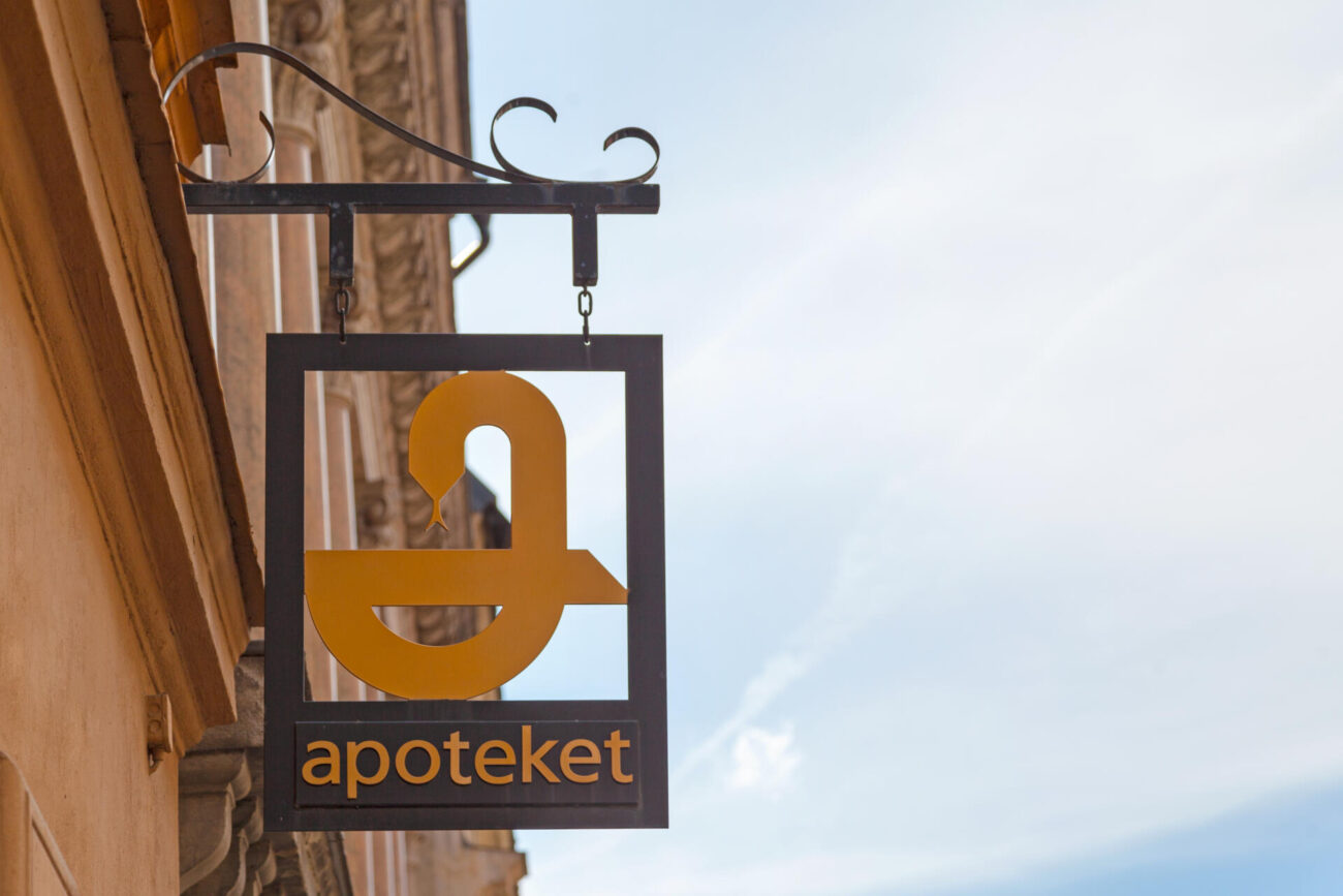 Ruotsalaisen Apoteket-ketjun logo katukuvassa.