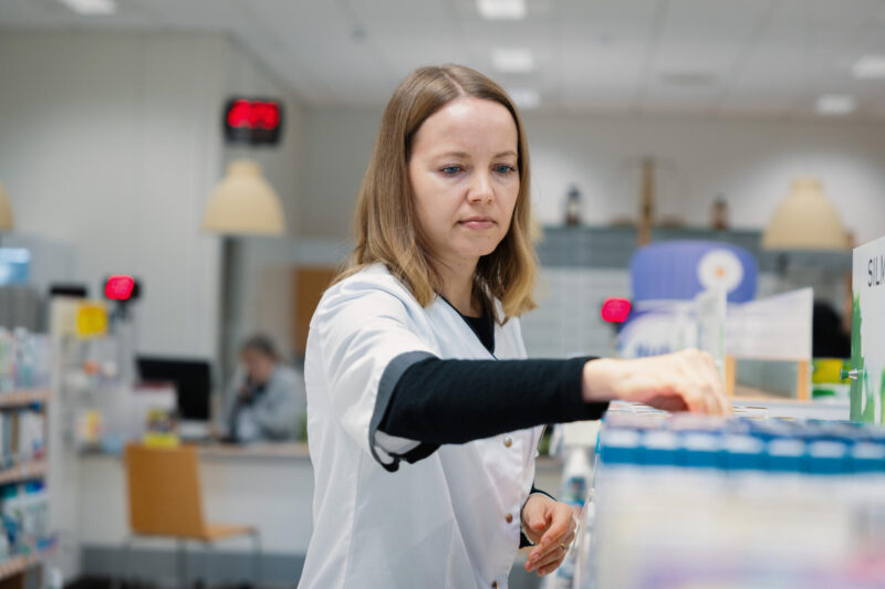 Hanna Ylä-Rautio järjestämässä itsehoitolääkehyllyä apteekissa.